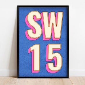 May include: A framed print with a blue background and white text that reads "SW15" in a bold, 3D-style font. The letters are outlined in pink and have a yellow shadow.