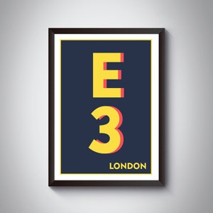 Puede incluir: Una impresión enmarcada con un fondo azul marino y texto amarillo que dice "E3 LONDON". La "E" y el "3" están en negrita, sin serifas, con un contorno rojo.