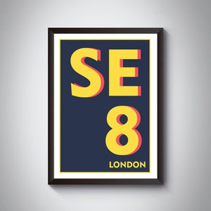 Könnte beinhalten: Ein gerahmter Druck mit einem gelben und roten Design. Der Druck zeigt den Text "SE8 LONDON" in einer fetten, serifenlosen Schrift.