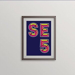 May include: Framed print with a navy blue background and the text "SE 5" in yellow and pink geometric lettering.