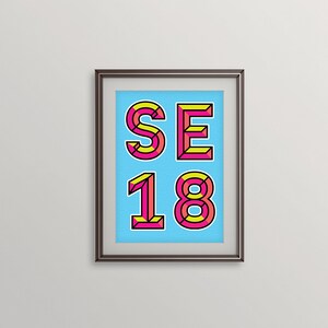 May include: A framed print with a blue background and the text "SE 18" in pink and yellow outlined letters.