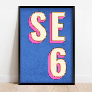 Könnte beinhalten: Ein gerahmter Druck mit blauem Hintergrund und weißen Buchstaben, die im Retro-Stil "SE 6" sagen. Die Buchstaben sind in Pink und Gelb umrandet.