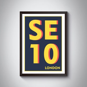 Peut inclure: Une impression encadrée avec un fond bleu marine et un texte jaune qui dit "SE10 LONDON". Le texte est souligné de rouge.