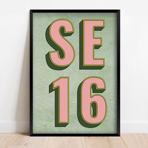 Könnte beinhalten: Ein gerahmter Druck mit grünem Hintergrund und rosa Buchstaben, die "SE 16" lesen.