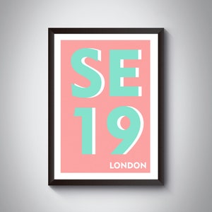 Könnte beinhalten: Ein gerahmter Druck mit rosa Hintergrund und dem Text "SE19 LONDON" in türkisfarbenen Buchstaben.