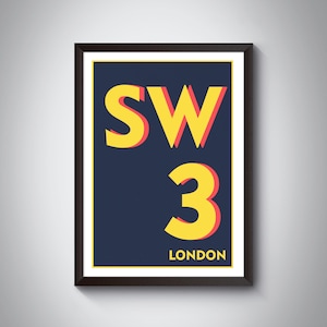 May include: A framed print with a navy blue background and yellow text that reads "SW3 LONDON". The "SW3" is in a large, bold font with a red outline.