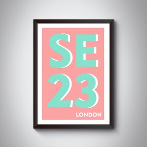 Peut inclure: Impression d'art encadrée avec un fond corail et le texte "SE 23 LONDON" en turquoise et blanc. L'œuvre est dans un cadre noir.