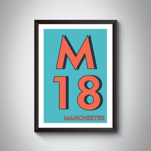 Op de afbeelding: Een ingelijste poster met een blauwe achtergrond en de tekst "M18 MANCHESTER" in rood en zwart.