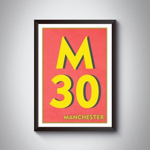 Op de afbeelding: Een ingelijste poster met een rode achtergrond en gele tekst. De tekst luidt "M30 MANCHESTER".