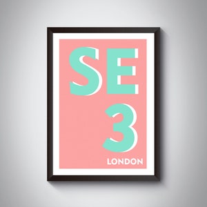 May include: A framed print with a pink background and turquoise text. The text reads "SE3 LONDON".