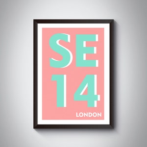 Puede incluir: Una impresión enmarcada con fondo rosa y texto turquesa. El texto dice "SE14 LONDON".
