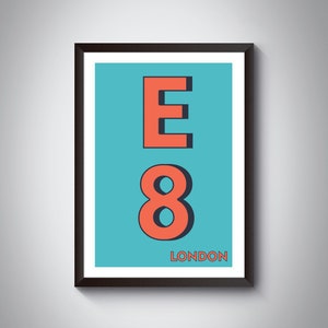 May include: Framed art print with the letters "E" and the number "8" in coral against a teal background. The word "LONDON" is printed in white at the bottom. The artwork is encased in a black frame.