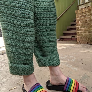 May include: Green crocheted pants with rainbow striped slides.