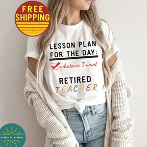 Op de afbeelding: Wit T-shirt met de tekst "LESSON PLAN FOR THE DAY: whatever I want RETIRED TEACHER" in zwarte en kleurrijke letters. Het woord "RETIRED" is in regenboogkleuren.