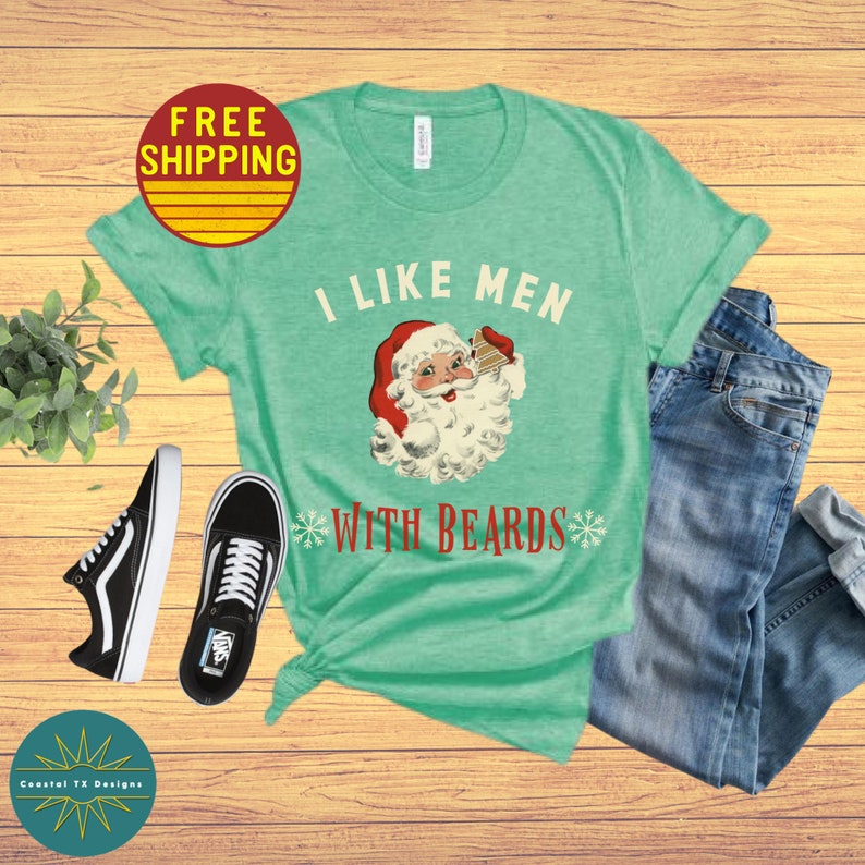 Op de afbeelding: Een groen T-shirt met de tekst "Ik hou van mannen met baarden" en een cartoonafbeelding van de kerstman die een stuk taart vasthoudt.