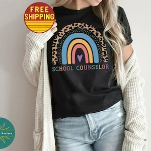 May include: A black t-shirt with a rainbow and leopard print design. The text "SCHOOL COUNSELOR" is printed below the rainbow.