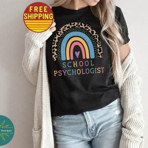 May include: Black t-shirt with a rainbow and leopard print design. The text "School Psychologist" is printed below the rainbow.