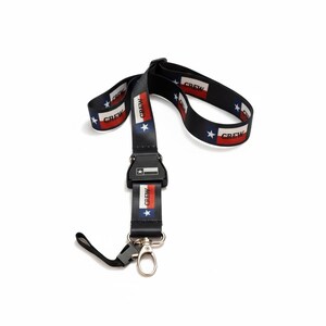 May include: Black lanyard featuring a Texas flag design. The lanyard has the Texas flag colours of red, white, and blue, with the word "CREW" printed on the strap. It has a black plastic clasp and a metal clip.