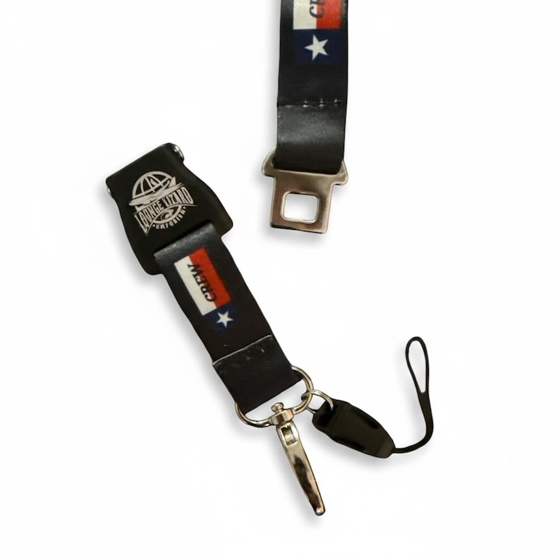 May include: Black lanyard with a metal clasp and a detachable loop. The lanyard features the word "CREW" with a red, white, and blue design, and the words "LOUNGE LIZARD" on the buckle.