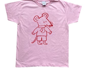 Può includere: T-shirt rosa chiaro con illustrazione di un topo rosso a cartoni animati. Il topo indossa sciarpa, pantaloncini e scarpe. La t-shirt ha girocollo e maniche corte.