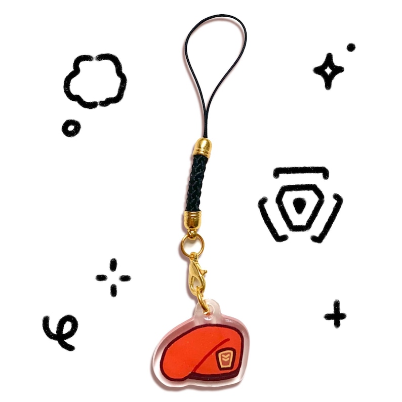 Pu&ograve; includere: Un ciondolo in acrilico trasparente con un design a basco rosso, hardware color oro e un cordino intrecciato nero. Il ciondolo &egrave; attaccato a un fermaglio color oro e un anello nero. Lo sfondo presenta grafiche nere in stile doodle.