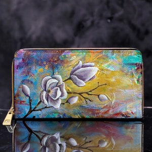 Cartera de cuero vegano con cremallera con flores de magnolia y mariposa monarca. Contempla la obra de arte de Sarah Camille Art