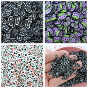 May include: Assortment of Halloween-themed resin charms in various shapes and colors, including black and white coffins, white skulls with red accents, and purple and green monsters.