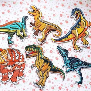 May include: Six colourful dinosaur iron-on patches. The patches feature a variety of dinosaurs, including a stegosaurus, a triceratops, a tyrannosaurus rex, and a velociraptor. The patches are perfect for adding a touch of fun to clothing, bags, or other accessories.