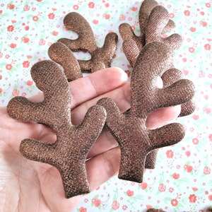 Op de afbeelding: Een set van zes bruine glitter rendiergewei. De gewei zijn gemaakt van vilt en hebben een glinsterende afwerking.