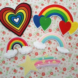 May include: Five colourful iron-on patches featuring rainbows, hearts, and a shooting star. The patches are perfect for adding a whimsical touch to clothing, bags, or other fabric items.