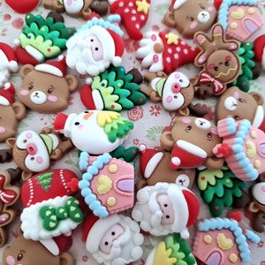 May include: Assortment of colourful Christmas-themed resin ornaments featuring various characters and designs, including Santa Claus, reindeer, gingerbread people, and houses.