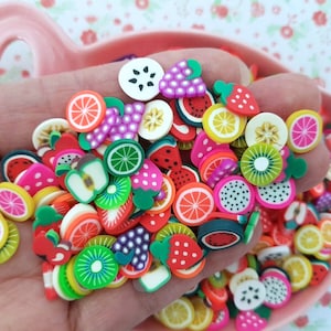 Peut inclure: Un assortiment de charmes en pâte polymère en forme de fruits colorés, notamment des fraises, des pastèques, des kiwis, des citrons et des raisins. Ces charmes sont parfaits pour ajouter une touche de fantaisie à vos bijoux, vos créations et autres projets.