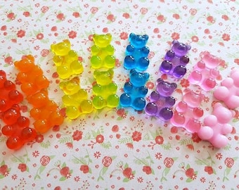 Puede incluir: Surtido de caramelos gomosos con forma de osito en varios colores, incluyendo naranja, amarillo, azul, morado y rosa.