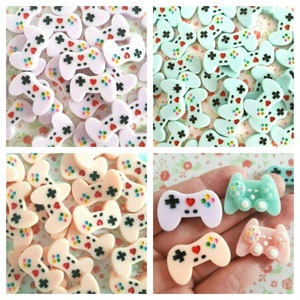 May include: Assortment of colorful miniature plastic game controllers. The controllers are in various shades of pink, blue, and green. Some of the controllers have a heart-shaped button on the front.
