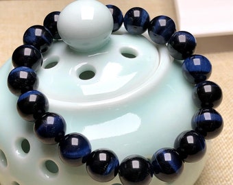 May include: A blue and black tiger's eye beaded bracelet. The beads are round and have a smooth, polished finish.