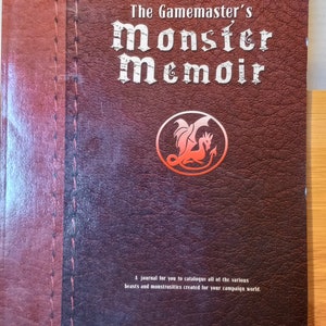 May include: A brown journal titled "The Gamemaster's Monster Memoir." The cover has embossed text and a circular emblem with a dragon. The journal is designed for cataloguing beasts and monstrosities for a campaign world.
