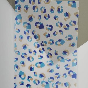 Könnte beinhalten: Ein weißes Blatt Papier mit einem blauen, braunen und violetten Leopardenmuster.
