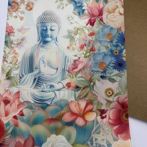Peut inclure: Une statue bleue et blanche de Bouddha assis en position de méditation entourée de fleurs colorées. Les fleurs sont dans des tons de rose, rouge, bleu et blanc.