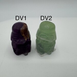 May include: Two small, hand-painted figurines of Darth Vader, one in purple and gold, the other in green. The figurines are labeled "DV1" and "DV2".