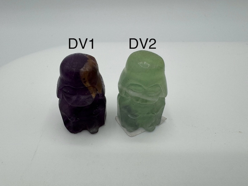 May include: Two small, hand-painted figurines of Darth Vader, one in purple and gold, the other in green. The figurines are labeled "DV1" and "DV2".