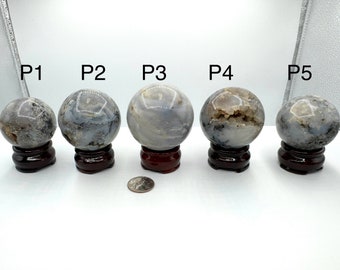 May include: Five agate spheres of varying sizes, each with a unique pattern of grey and white, displayed on small wooden stands. The spheres are labelled P1 through P5.