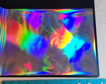 以下が含まれることがあります： 虹色のホログラフィックビニールシート。ビニールはテクスチャ加工されており、幅は約30cmです。