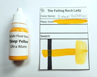 Puede incluir: Una botella de pintura acrílica fluida 'Deep Yellow' junto a una tarjeta de muestra de color. La botella tiene una etiqueta blanca con texto negro. La tarjeta muestra el nombre del color, 'Deep Yellow', y una muestra pintada del color.