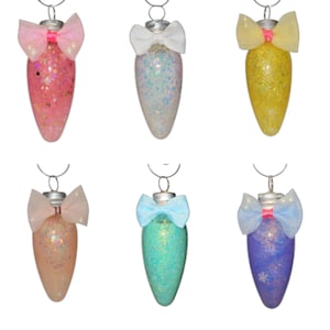 May include: Six glitter-filled, teardrop-shaped ornaments in various colors: pink, white, yellow, peach, teal, and purple. Each ornament has a silver cap and a sheer bow. The ornaments are designed for holiday or seasonal decor.