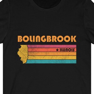 Pode incluir: Camiseta preta com um gráfico de estilo vintage do estado de Illinois com o texto "Bolingbrook, Illinois" em laranja.