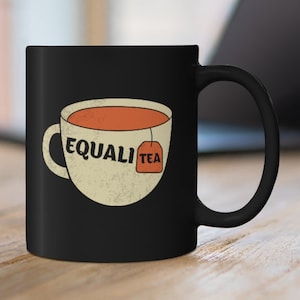 May include: Black ceramic mug with a white teacup and tea bag design. The tea bag has the word "EQUALI TEA" printed on it.
