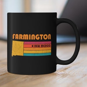 May include: Black ceramic coffee mug with a retro design featuring the text "FARMINGTON" and a stylized outline of the state of New Mexico with the text "NEW MEXICO" below.