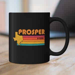 Puede incluir: Taza de café negra con un contorno blanco del estado de Texas y el texto "PROSPER * TEXAS" en un esquema de colores arcoíris.