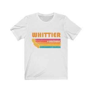 May include: White t-shirt with a retro-style graphic of the state of California with the text "WHITTIER *CALIFORNIA" printed on it.