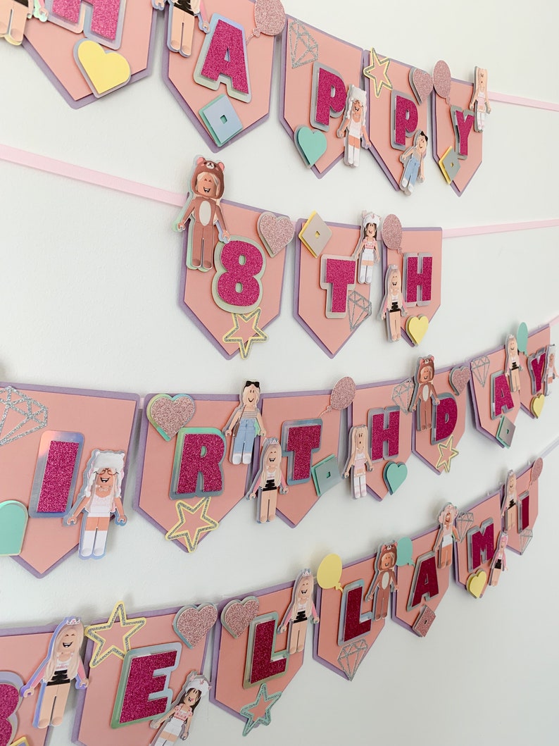 Puede incluir: Bandera de cumplea&ntilde;os rosa y morada con las palabras "Happy 8th Birthday Llama" en letras rosas brillantes. La bandera est&aacute; decorada con corazones, estrellas y peque&ntilde;as figuras de personas con diferentes atuendos.